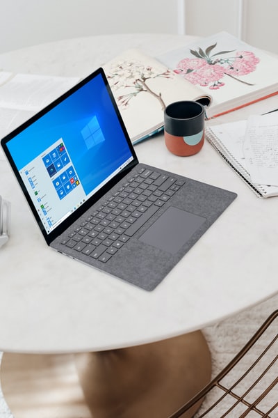 白色桌子上的灰色微软surface笔记本电脑